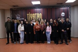 Tiyatro sahnesinde grup fotoğrafı, sanat ve tiyatro etkinliği.